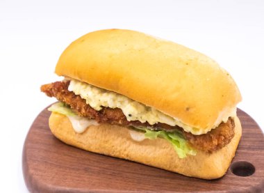 Çıtır tavuk şnitzel ve yumurta salatalı sandviç. Tahta tahtada Zesty Yuzu soslu. Beyaz arka planda yemek menüleri.