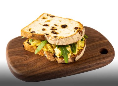 Gurme Tavuklu Sandviç Taş Fırınlanmış Üzümlü Ekmek Tahta kesim tahtası beyaz arka planda fast food menülerinin yan görüntüsü