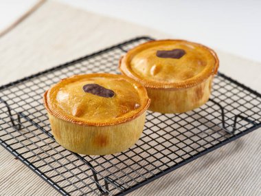 Altın Tavuklu Mantarlı Turtalar yumuşak hamur kabuklarıyla kaplanmış siyah kablo soğutma rafında konforlu yiyeceklerin manzarası