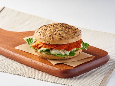 Tavuk Tandır Tavuğu Tandoori Multi tahıllı sandviç marullu, ve ahşap kesim tahtası tarafında kremalı sos öğle yemeği menüsü