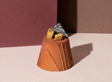 Pastanenin arka planında izole edilmiş altın taneli düşük şekerli çikolatalı kremalı pasta.