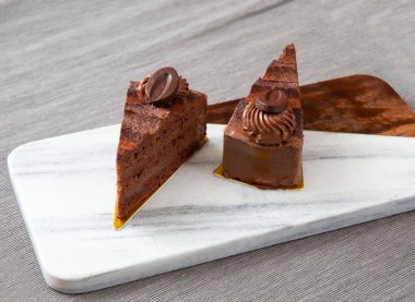 Valrhona Koyu Çikolatalı Pasta Mermer Tahtada Dilimler Hoşgörü Tatlısının yan görünüşü