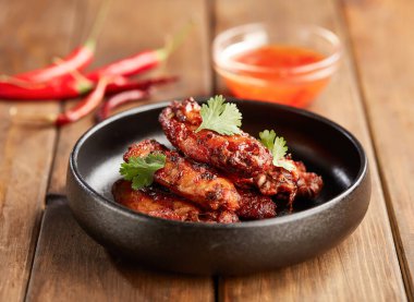 Baharatlı Tavuk Kanatları ve Tatlı Acı biber sosu. Tabak kenarında çıtır çıtır aperatif.