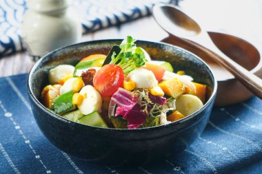 Japon Bahçe Salatası, sebzeler, tofu, kiraz domatesleri, mısır, salatalık ve yapraklı yeşillikler ile servis edilir. Kremalı mozzarella topları ve Vinaigrette sosuyla birlikte.