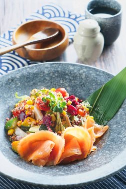 Füme somon kinoa salatası mısır, kiraz domatesleri, pancar ve taze sebzelerle servis edilir.