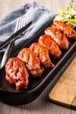 Baharatlı Bufalo Tavuk Kanatları ve Keskin Soslu Gourmet aperatifi 'nin yakın çekimde sunuluyor.