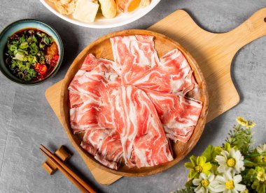 İnce dilimlenmiş kuzu göbeği Çin yemeğinin ahşap tabağında çiğ et tabağı.