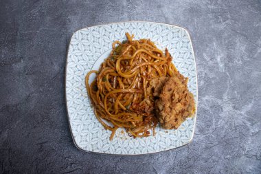 Asya yemeklerinin üst tabağında kızarmış tavuklu baharatlı barbekü eriştesi.