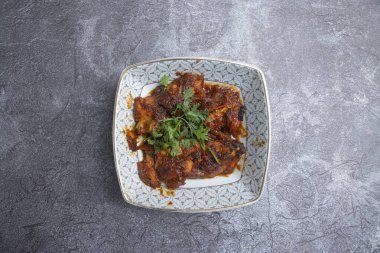 Baharatlı Biberli Tavuk Masala, Güney Asya mutfağının üst tabağında servis ediliyor.