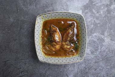 Dekoratif bir kasede baharatlı karides, Chingri Bhuna Malaikari manzaralı.