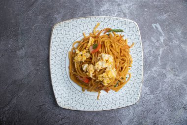 Çırpılmış yumurta eriştesi, sebzeli omlet ve çırpılmış yumurta Çin yemeği tabağında servis edilir.