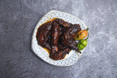 Lokanta yemeklerinin üst tabağında acı biberli jöleli tavuk kanadı.