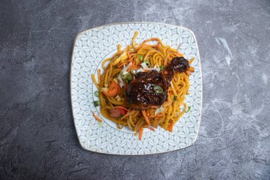 Sebzeli erişte ve soslu tavuk budu. Füzyon mutfağının üst tabağında.