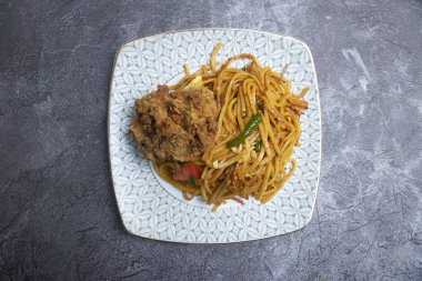 Sebzeli erişte ve bir parça kızarmış tavuk. Asya yemeklerinin üst tabaklarında.