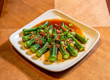 Çin Soğuk bamya salatası, sarımsak, acı biber ve soğan ile ahşap masa üzerinde Asya mutfağı manzarası