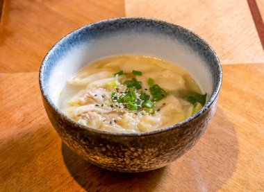 Çin Wonton Çorbası Scallions ve Susam tohumları ile ahşap masa başı Asya mutfağı manzaralı