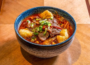 Hindibalı Sichuan Kaynamış Bifteği, Biberli Sichuan Biberi, ve ahşap masa başında acı biber Shui Zhu Niu Rou Baharatlı Biber Çorbası