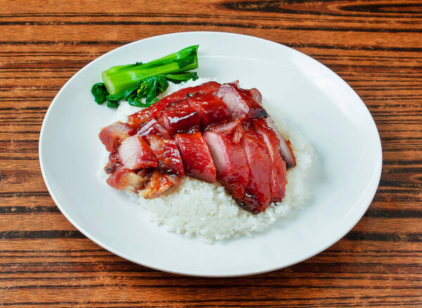 Cantonese BBQ Pork with Steamed Rice and Chinese Broccoli in plate on wooden table side view of Char Siu Rice