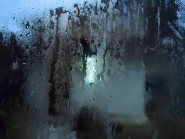 Yağmur suyu pencereden aşağı akar ve dışarıdan yansıma oluşturur. arkaplan, sunum ve sosyal medya için uygun.