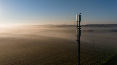 Güneşin doğuşunda Sisli Kırsal Bölgede 5G Hücre Kulesi