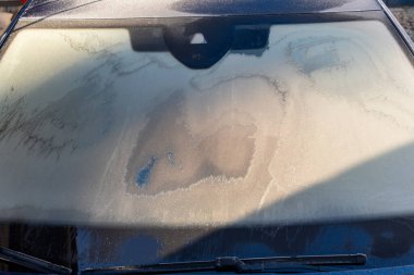 Frost patterns on a car windshield in sunlight. clipart