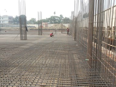 25 Temmuz 2024 Dhaka, Bangladeş. Görüntü hareketli bir inşaat alanı yakalıyor, işçilerle dolu özenle metal iskeleler dikiyorlar..