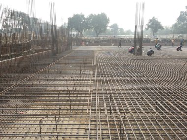 25 Temmuz 2024 Dhaka, Bangladeş. Görüntü, çelik kirişler ve kolonlardan oluşan bir inşaat alanının havadan görünüşünü ve birkaç işçiyi gösteriyor..