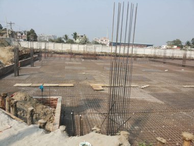 31 Temmuz 2024 Dhaka, Bangladeş. Görüntü, çimento levhası, metal iskelesi ve ön planda mavi bir nesne olan bitmemiş bir inşaat alanını gösteriyor..