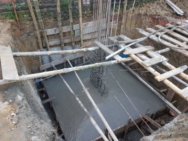 3 Temmuz 2024 Dhaka, Bangladeş. Temelinde derin bir çukur kazılmış bir inşaat alanı. Çukurda bir çimento yapı inşa ediliyor..