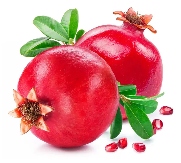 Beyaz zemin üzerinde yeşil yapraklı nar meyveleri.