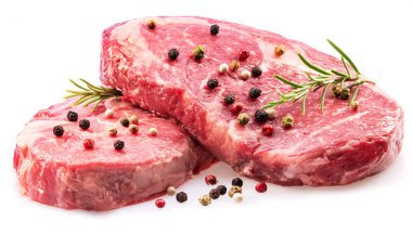Raw ribeye steaks with peppercorn and rosemary isolated on white background. Closeup. 
