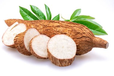 Beyaz arka planda yalıtılmış, yapraklı ve kasava dilimli Cassava yumrusu..