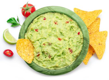 Guacamole sosu, içindeki malzemeler tortilla cipsi, beyaz arka planda popüler Meksika yemekleri..