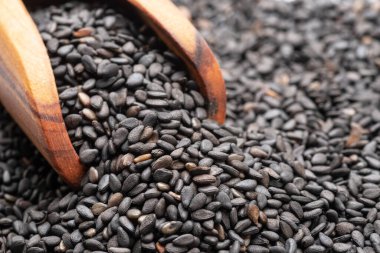 Kara kimyon tohumu yığınında tahta kepçe. Gıda arkaplanı.