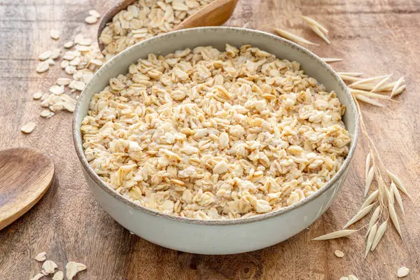 Tahta masada bir kase yulaf lapası ya da yulaf ezmesi. Üst görünüm.