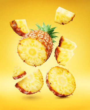 Ananas dilimleri ve ananas parçaları sarı arka planda havada uçuşuyor. Dosya kırpma yolları içeriyor.