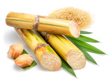 Şeker kamışı kesikleri ve beyaz arkaplanda izole edilmiş kahverengi şeker yığını.