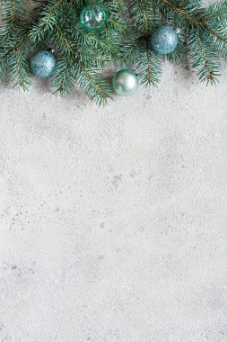 Noel arkaplanı köknar dalları ve oyuncaklarla dolu gri, şenlikli bir ruh hali, hediye sezonu. Kış tatili konsepti. Üst görünüm ve kopyalama alanı.