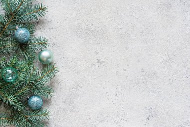 Noel arkaplanı köknar dalları ve oyuncaklarla dolu gri, şenlikli bir ruh hali, hediye sezonu. Kış tatili konsepti. Üst görünüm ve kopyalama alanı.