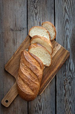 Kahverengi arka planda taze ekmek. Geleneksel buğday taze rustik ekmek, bir somun ekmek.