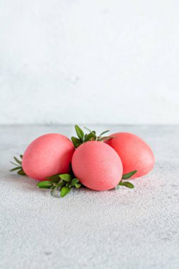 Gri arka planda pembe renkli Paskalya yumurtaları. Şenlikli Paskalya konsepti, tatilin zorunlu bir niteliği, seçici odaklanma