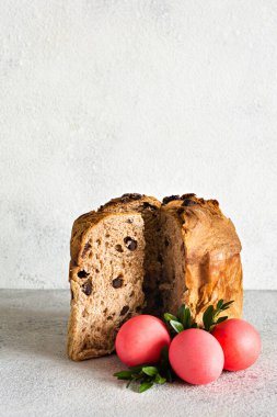 Çikolatalı Paskalya pastası, gri arka planda pembe yumurtalar. Geleneksel Paskalya konsepti, festival tablosu nitelikleri, seçici odak