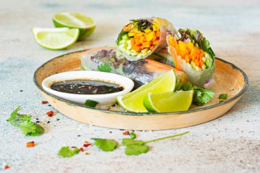 Pirinç kağıdı, çiğ sebze ve açık mavi arka planda acı soslu bitkilerden yapılmış taze Asya aperatifli börekler (Nem). Vietnam Yemekleri