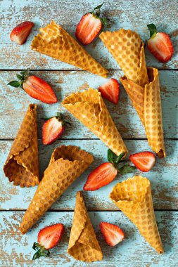 Dondurma için waffle külahları ve mavi arka planda olgun çilekler. Yaz yemeği konsepti, tatlı tatlı, güzel manzara..
