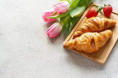 Anneler günün kutlu olsun, güzel bir kahvaltı, taze kruvasanlarla öğle yemeği tepside çilek, hediye olarak bir buket lale..