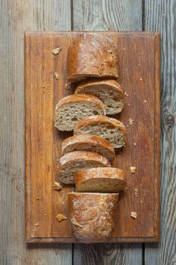 Tahta zemin üzerinde taze pişmiş karabuğday (tam tahıl) ekmeği. Hassas bir ekmek kırıntısı ve çıtır ekmek. Ekşi hamurlu ciabatta. Mayasız pişmiş yiyecekler..