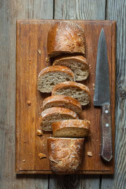 Tahta zemin üzerinde taze pişmiş karabuğday (tam tahıl) ekmeği. Hassas bir ekmek kırıntısı ve çıtır ekmek. Ekşi hamurlu ciabatta. Mayasız pişmiş yiyecekler..