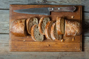 Tahta zemin üzerinde taze pişmiş karabuğday (tam tahıl) ekmeği. Hassas bir ekmek kırıntısı ve çıtır ekmek. Ekşi hamurlu ciabatta. Mayasız pişmiş yiyecekler..