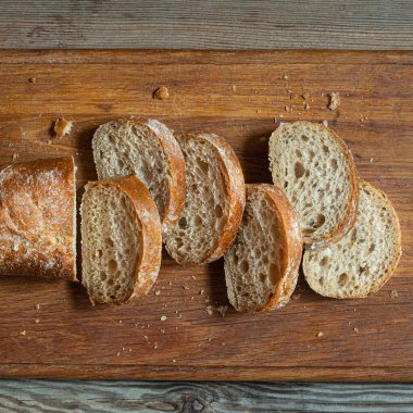 Tahta zemin üzerinde taze pişmiş karabuğday (tam tahıl) ekmeği. Hassas bir ekmek kırıntısı ve çıtır ekmek. Ekşi hamurlu ciabatta. Mayasız pişmiş yiyecekler..