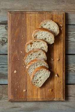 Tahta zemin üzerinde taze pişmiş karabuğday (tam tahıl) ekmeği. Hassas bir ekmek kırıntısı ve çıtır ekmek. Ekşi hamurlu ciabatta. Mayasız pişmiş yiyecekler..